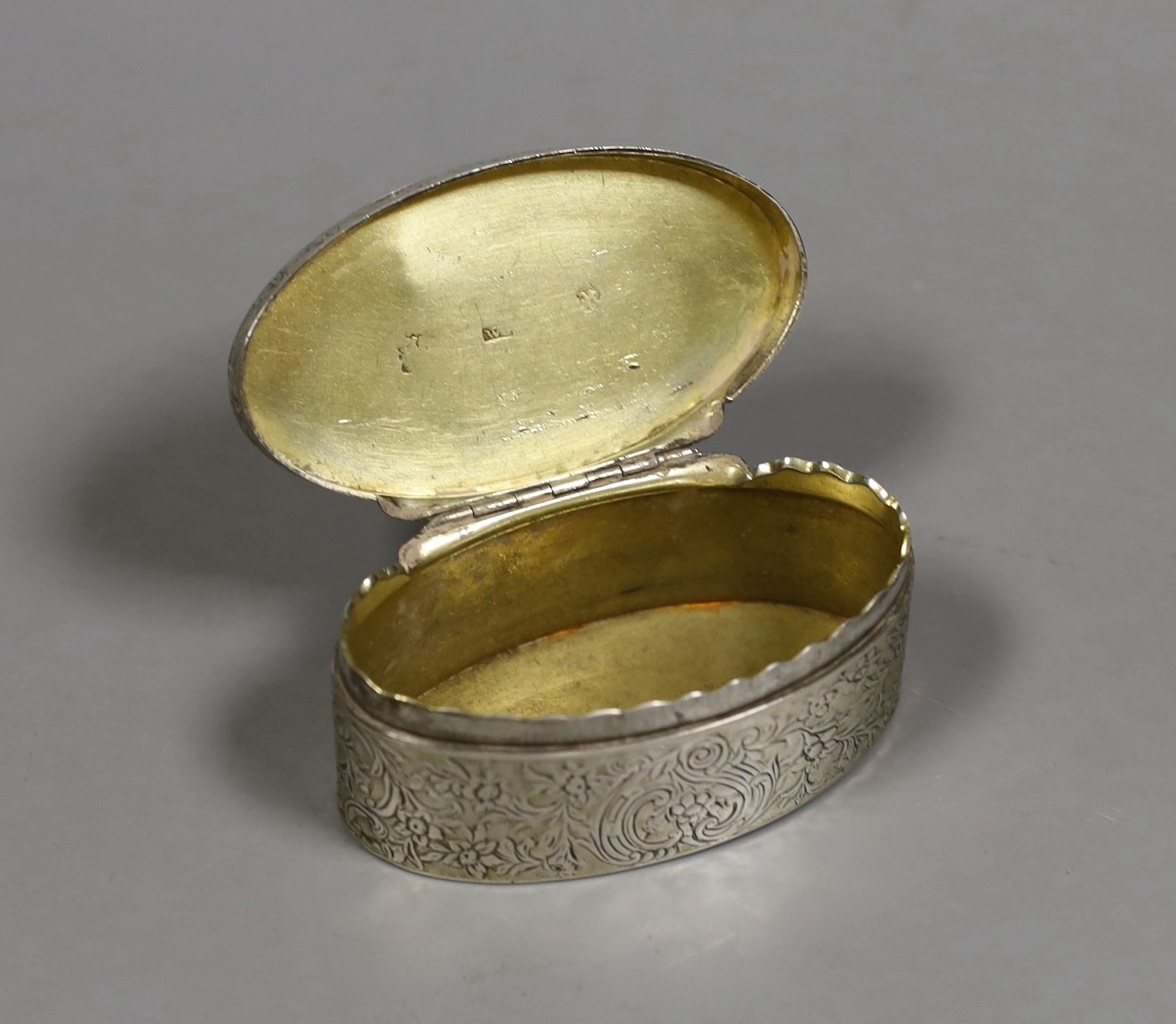 A late 18th century Continental silver snuff box, of oval form, with flower and scroll engraving, indistinctly marked, 9cm